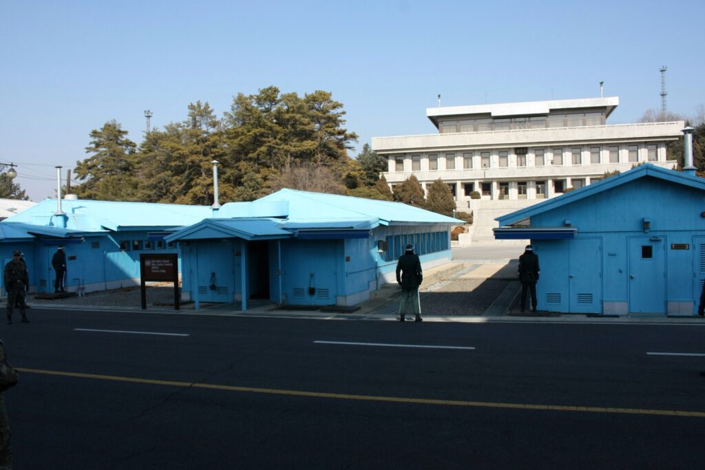 Durch die Mitte der blauen Baracken verläuft die Grenze. Das graue Gebäude im Hintergrund ist das Besucherzentrum von Nordkorea.